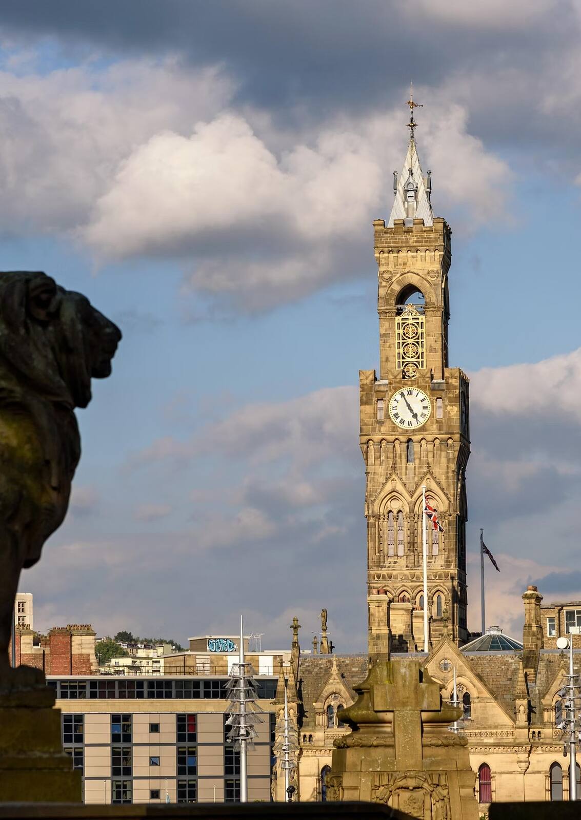 Bradford City Hall clocktower and stone lion at dusk